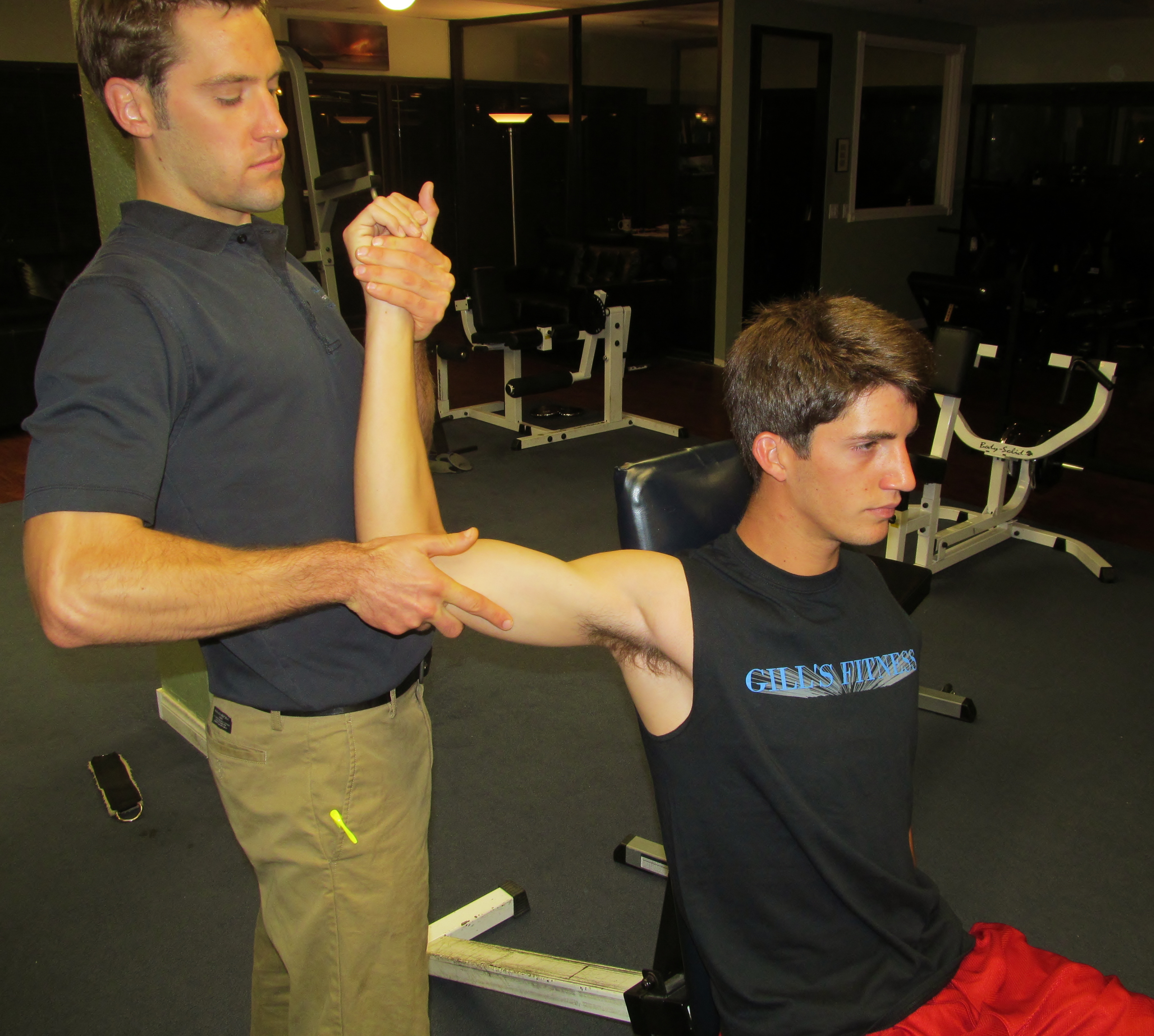 Trainer applying hands-on resistance to a young athlete